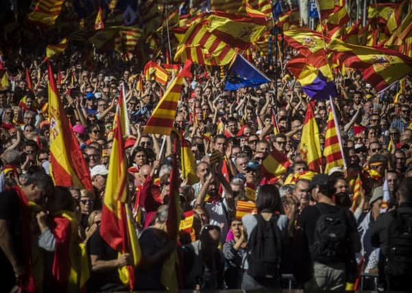 Nationalist activists march with Catalan, Spanish and European Union flags during a mass rally against Catalonia's declaration of independence in Barcelona. Picture: AP Photo/Santi Palacios