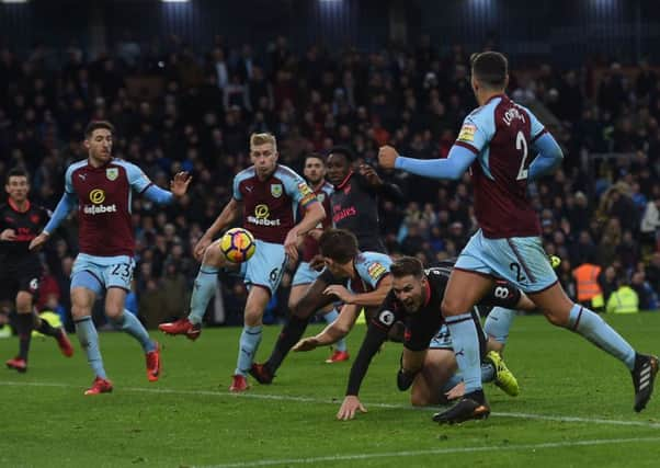 Aaron Ramsay goes down under the challenge of Burnleys James Tarkowski, but no red card was shown. Picture: Getty.