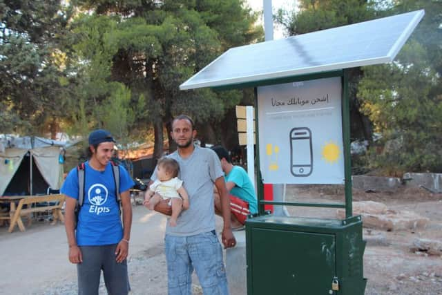 Alexandros Angelopoulos (left) with refugees at one of charging units on Samos. Picture: R Leask/University of Edinburgh/PA