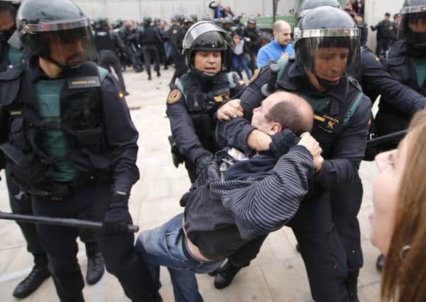 Spanish Guardia Civil officers drag a man outside a polling station in Sant Julia de Ramis on the day of Catalonia's disputed independence referendum. (Picture: AFP/Getty)