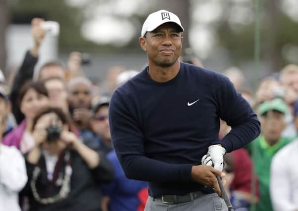 Tiger Woods watches his drive on the first hole during  practice round at Augusta.