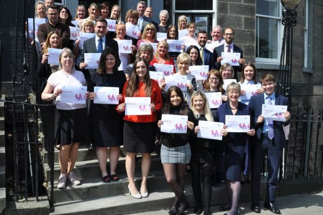 Balfour+Manson staff outside their office in Frederick Street, Edinburgh, with their Dementia Friends certificates.