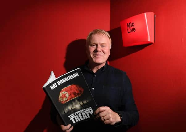 Dave McKinnon with a copy of his novel, written under the pen name Nat Donaldson. Picture: John Devlin