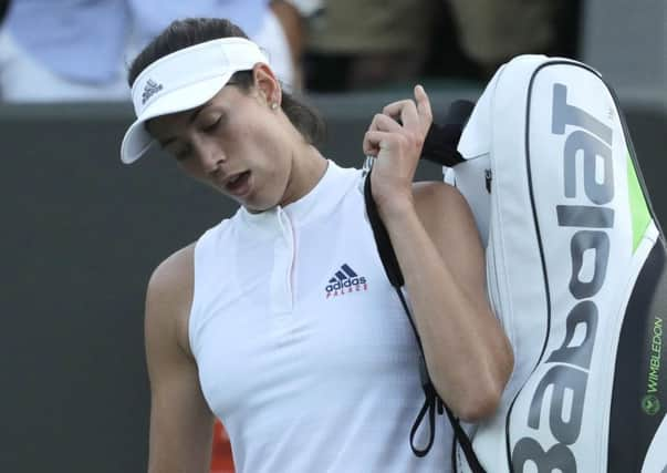 Defending champion Garbine Muguruza leaves the court after losing to Alison Van Uytvanck of Belgium. Picture: Ben Curtis/AP