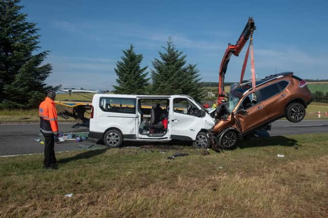 A car is removed from the A96 between Huntly and Keith in Moray where a five people have died and five more were injured after a crash between a minibus and a car. Picture; PA