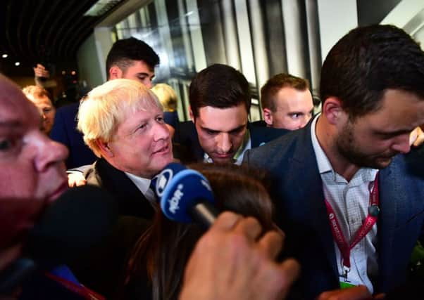 The intrepid Ross Thomson keeps Boris Johnson from harm as he heads to his fringe meeting in Birmingham. Picture: PA