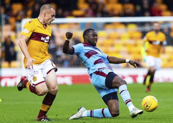 Dundee's Genseric Kusunga competes with Motherwell midfielder Liam Grimshaw. Picture: SNS