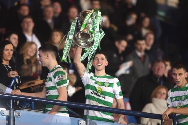 Celtic midfielder Ryan Christie holds the Betfred Cup trophy aloft. Picture: John Devlin