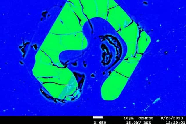 This is a false color electron-microscope image of a resorbed apatite crystal (green) in pitchstone glass (blue). The composition of the pitchstone glass and the characteristic mineral textures are identical in the studied pitchstone sites of the Sgùrr of Eigg and "igh-sgeir, although over 30km apart, indicating a common origin, and thus a large and geographically widespread volcanic eruption. Picture: SWNS