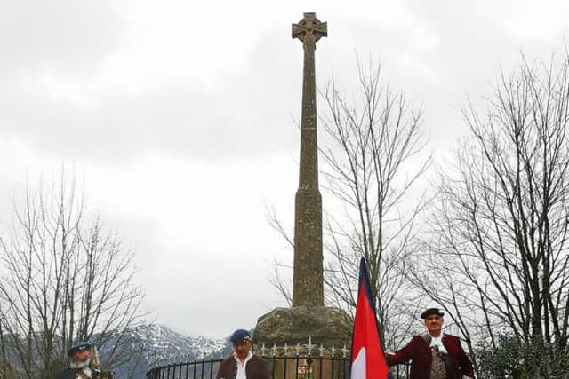 The group carry a red, blue and white flag used in the early Jacobite rebellions