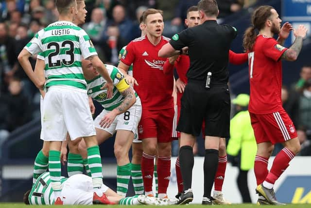 Referee Craig Thomson shows a red card to Dominic Ball as Ryan Christie lies injured on the turf. Picture: Getty