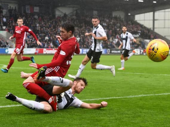 Aberdeen's Scott Wright is challenged by St Mirren's Gary MacKenzie at a wet Simple Digital Arena