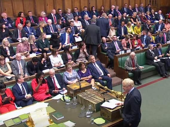 Tory MP Phillip Lee, pictured centre, walked across the House of Commons floor during a statement by the Prime Minister, Boris Johnson. PA