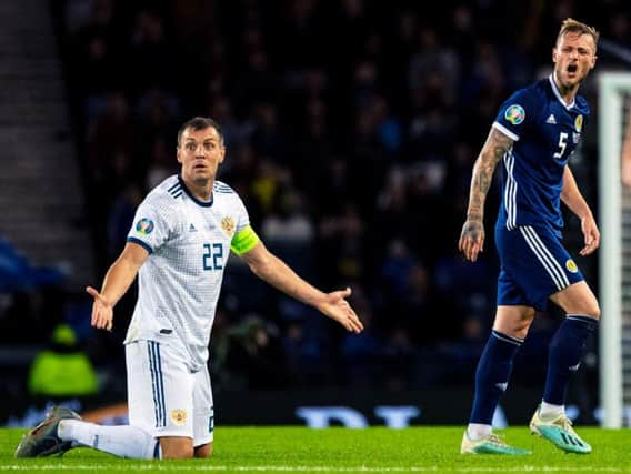 Artem Dzyuba alongside Scotland's Liam Cooper.