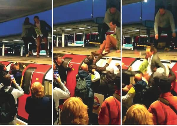 Angry commuters drag a protester from the top of a tube train at Canning Town. Picture: SWNS