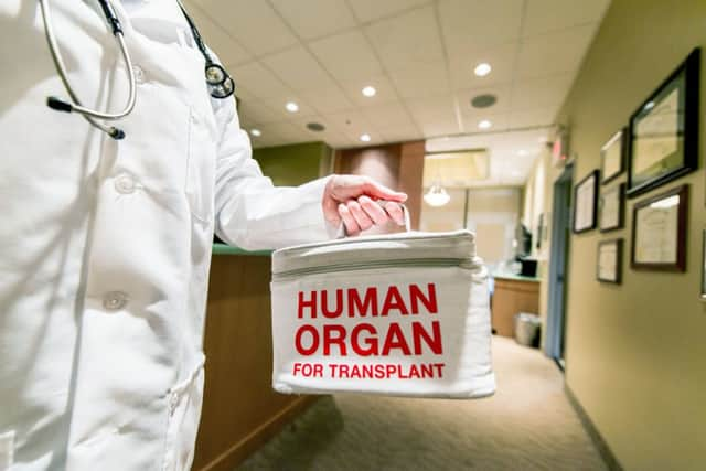 A doctor taking or delivering a bag containing a human organ for transplant