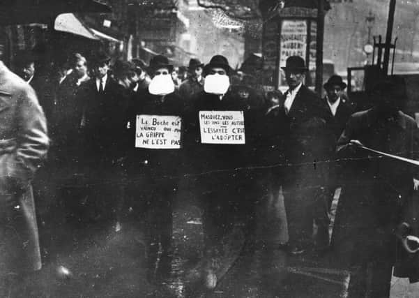 Two men wearing and advocating the use of flu masks in Paris during the Spanish flu epidemic in March 1919 (Picture: Topical Press Agency/Getty Images)